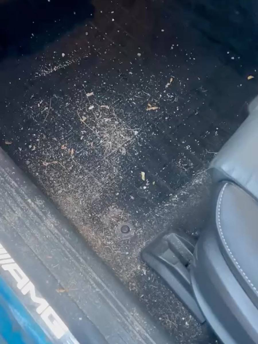 Mercedes-AMG driver’s footwell covered in dirt and debris, before the detail