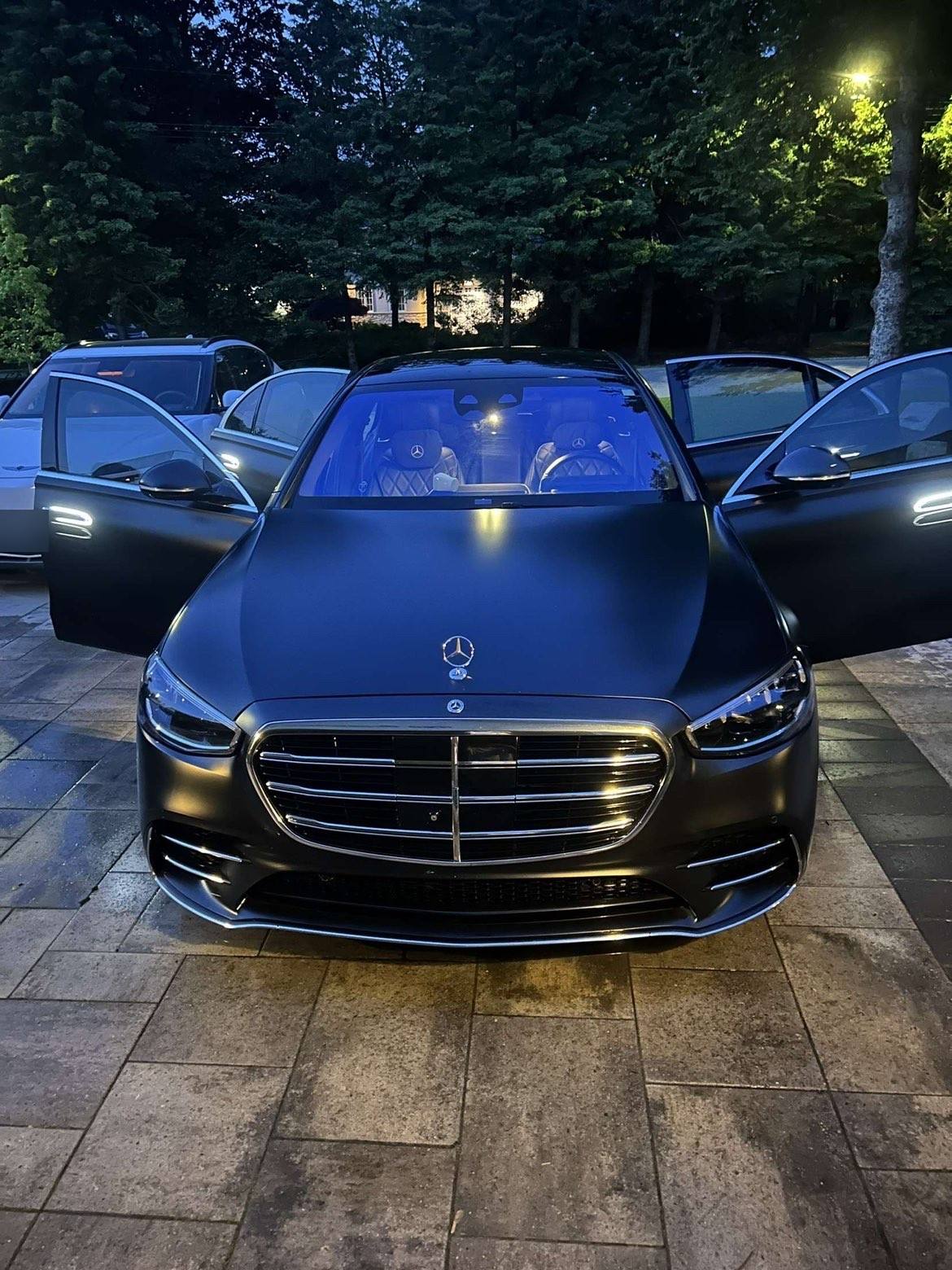 Satin black Mercedes S-Class from the front after a full detail, doors open and cabin lit