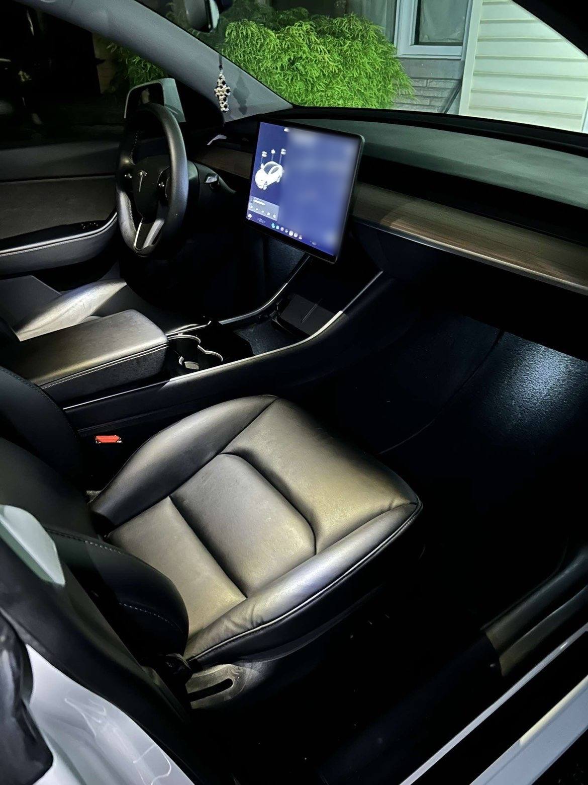 Front seat, console and screen of a white Tesla after an interior detail
